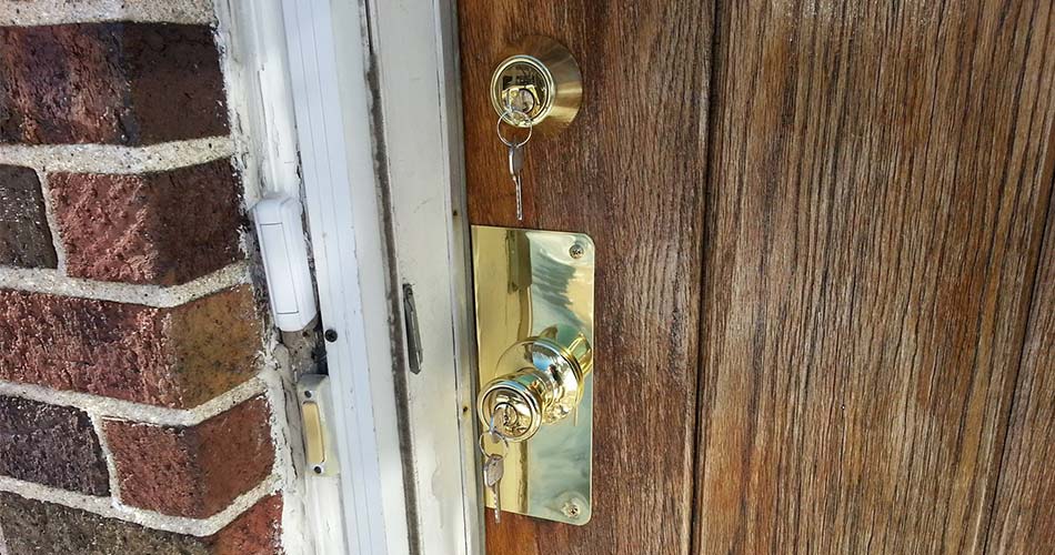 A deadbolt is featured on a residential front door, which is made of finished wood.