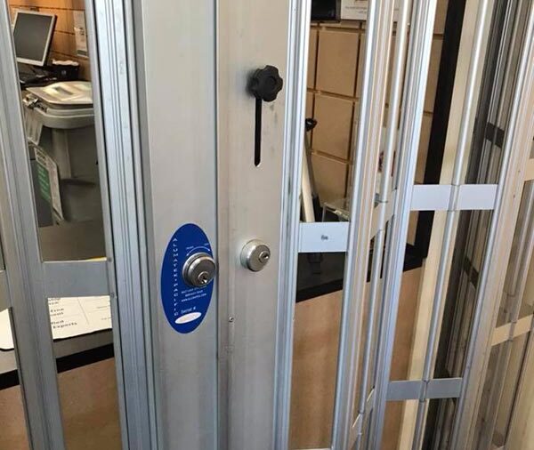 lock repair on a commercial folding security door at a UPS store lock repair on a commercial folding security door at a UPS store